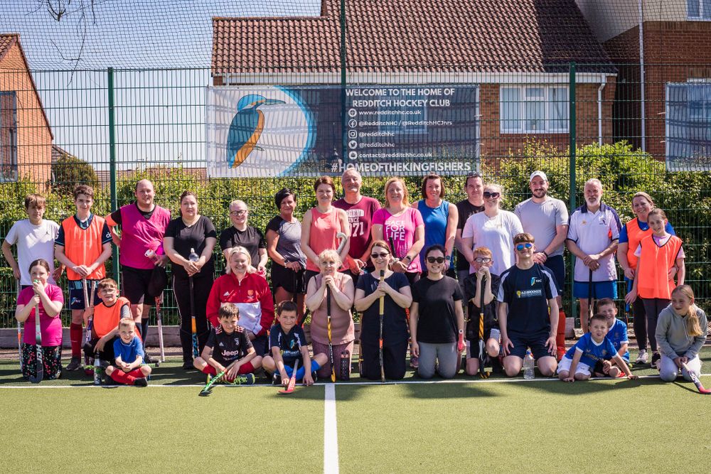 Group of happy hockey players in Redditch after playing sports in the sunshine at Redditch Hockey Club