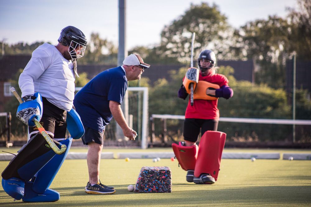 Hockey goalkeeping coach putting goalkeepers through their paces using coaching equipment at Redditch Hockey Club