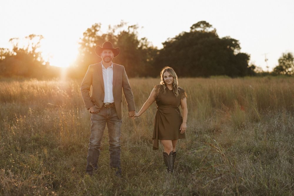 Silhouetted figures walk through a golden field at sunset creating a dreamy romantic atmosphere.