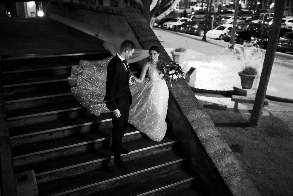 Black and white photo of couple on stone steps during nighttime wedding photography.