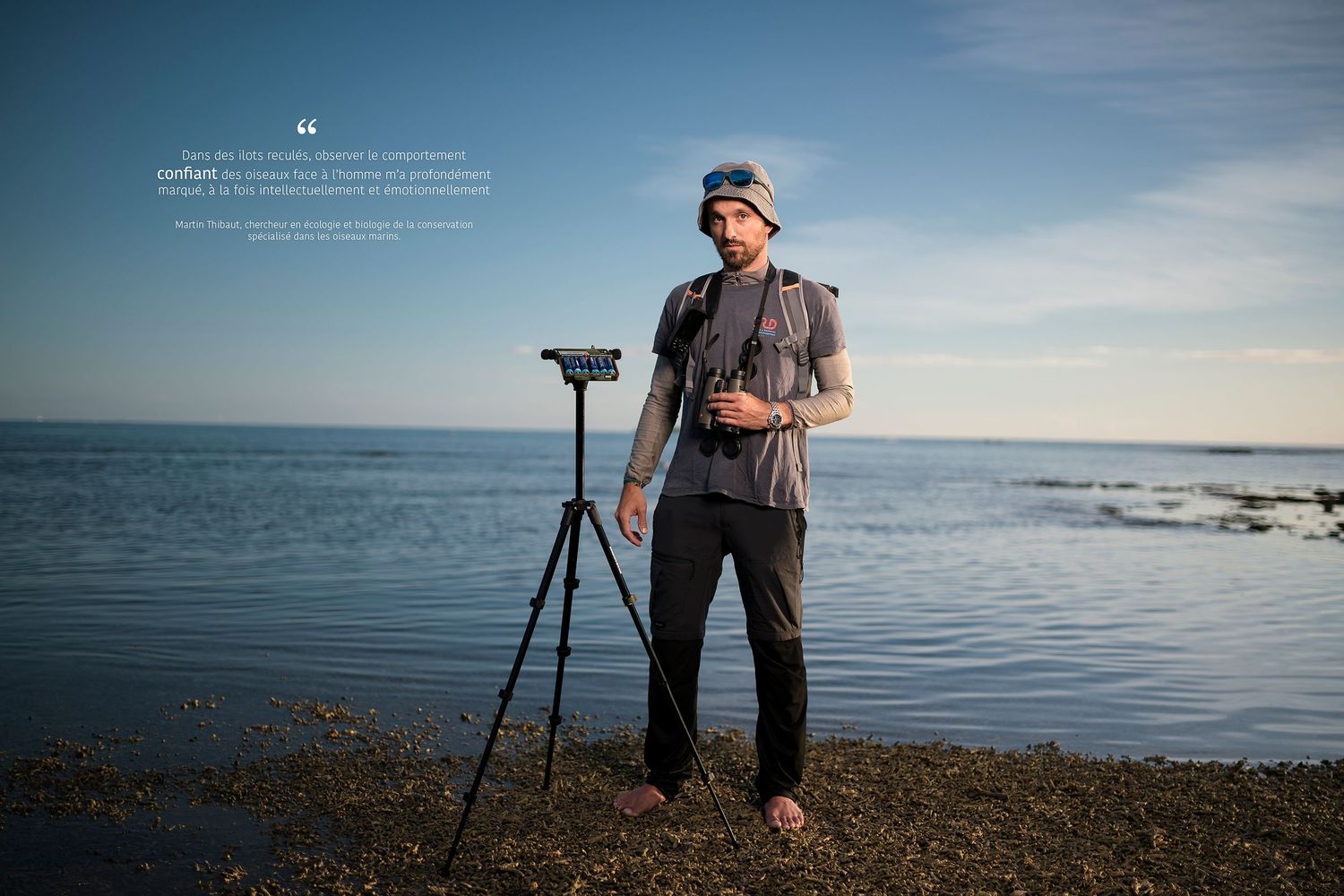 Jeune chercheur de l'IRD spécialiste de la conservation des oiseaux marins, posant devant la mer, coucher du soleil.
