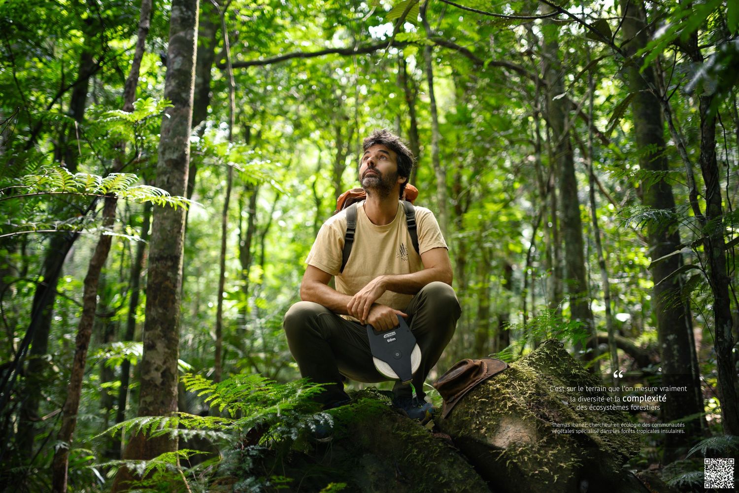 Portrait d'un botaniste de l'IRD, accroupi sur un rocher dans une forêt tropicale en Nouvelle-Calédonie