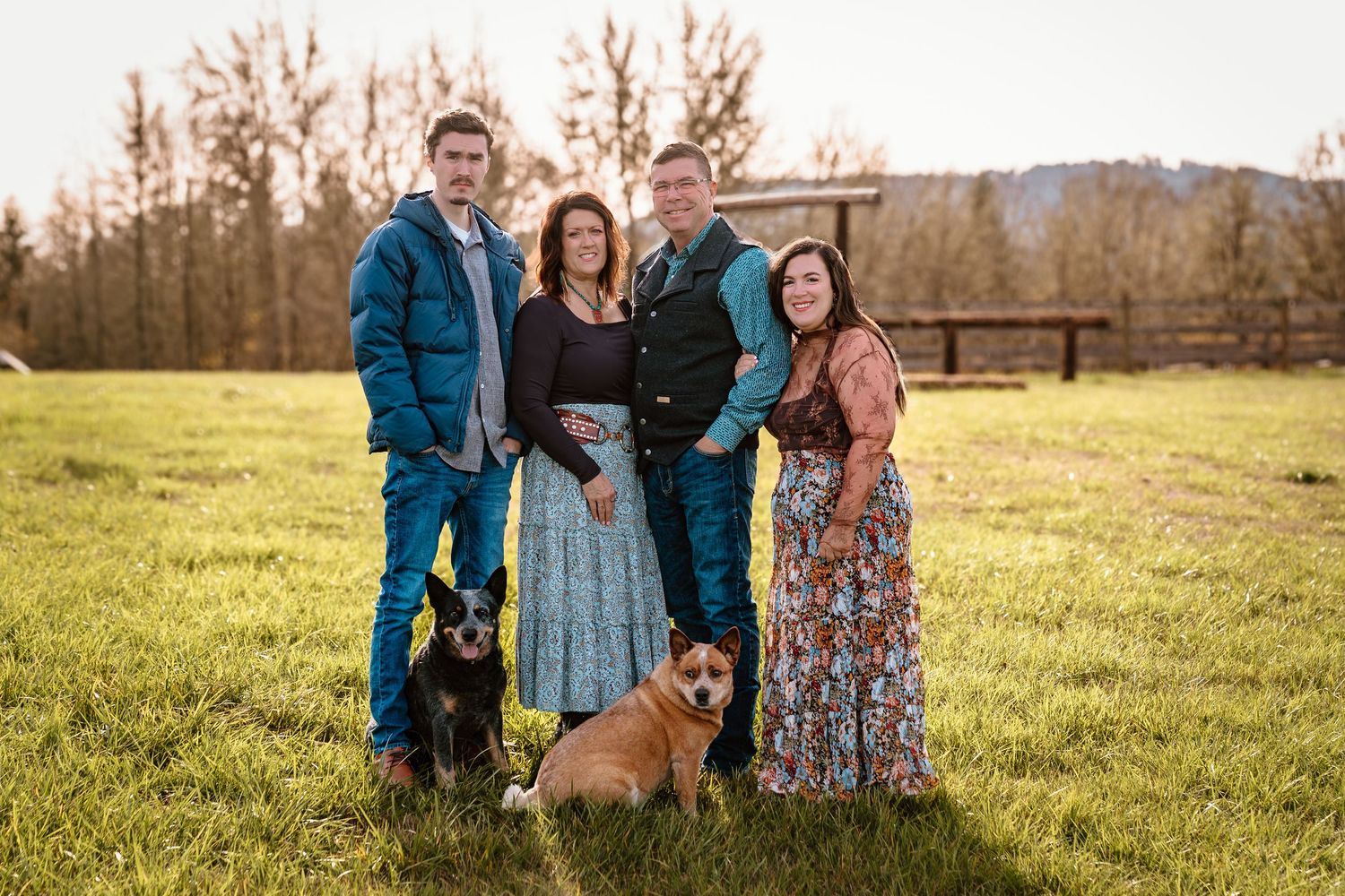 Family and dog portrait session in a sunny field during golden hour.