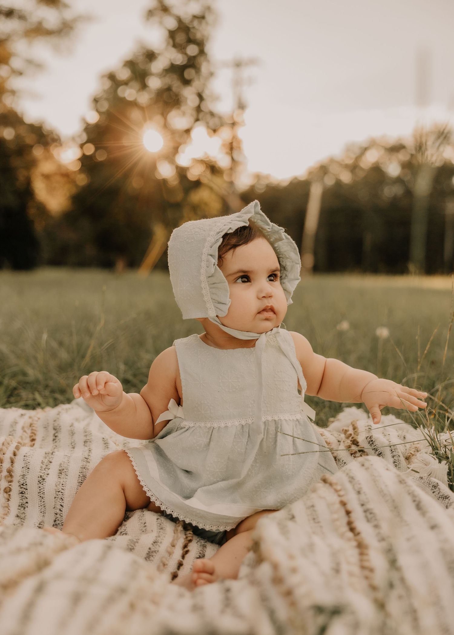 Baby sitting outdoors during a warm family photography session by Dahlhouse Images.