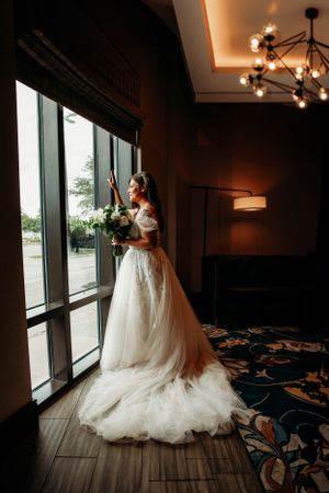 Elegant bridal portrait at a luxury Branson wedding venue featuring dramatic window light and a lace train.