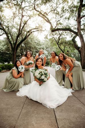 Bride and bridesmaids laughing on a stone patio at a GEorgia wedding venue, captured by L. Ballenger Photography, a Branson Mo Photographer.