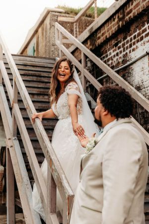 Bride and groom posing on rustic wooden stairs by Branson, MO Photographer L. Ballenger Photography.