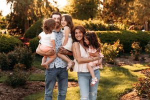 Family of four in a scenic park setting at sunset, captured by L. Ballenger Photography.
