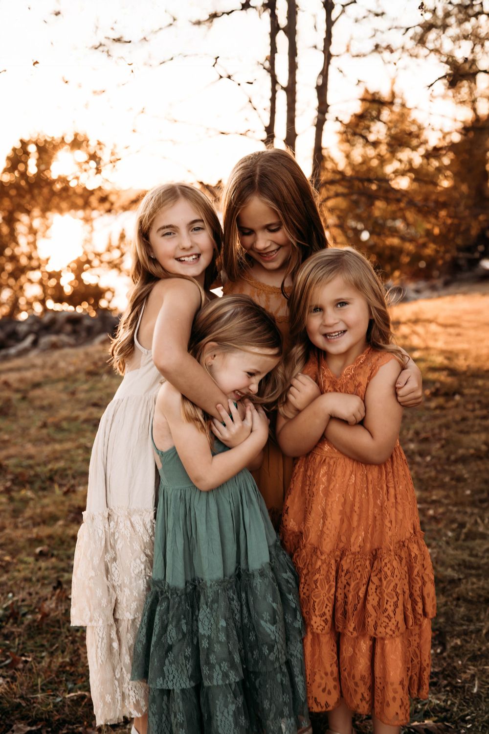 Motherhood photographer in Branson capturing a sweet moment with four daughters in a forest setting.