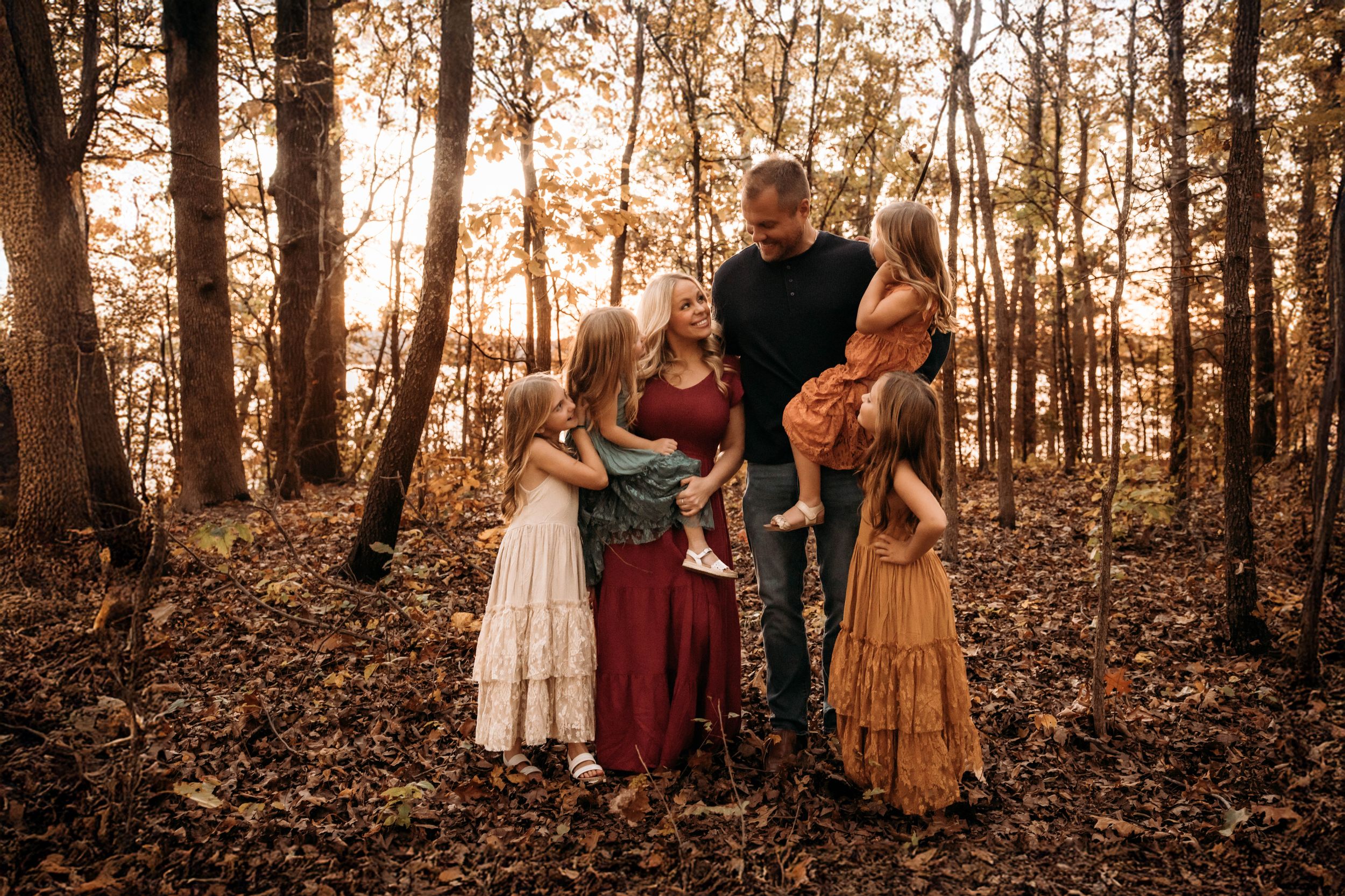 Large family portrait in a sun-drenched Branson forest during an autumn photo session in Branson, Mo.