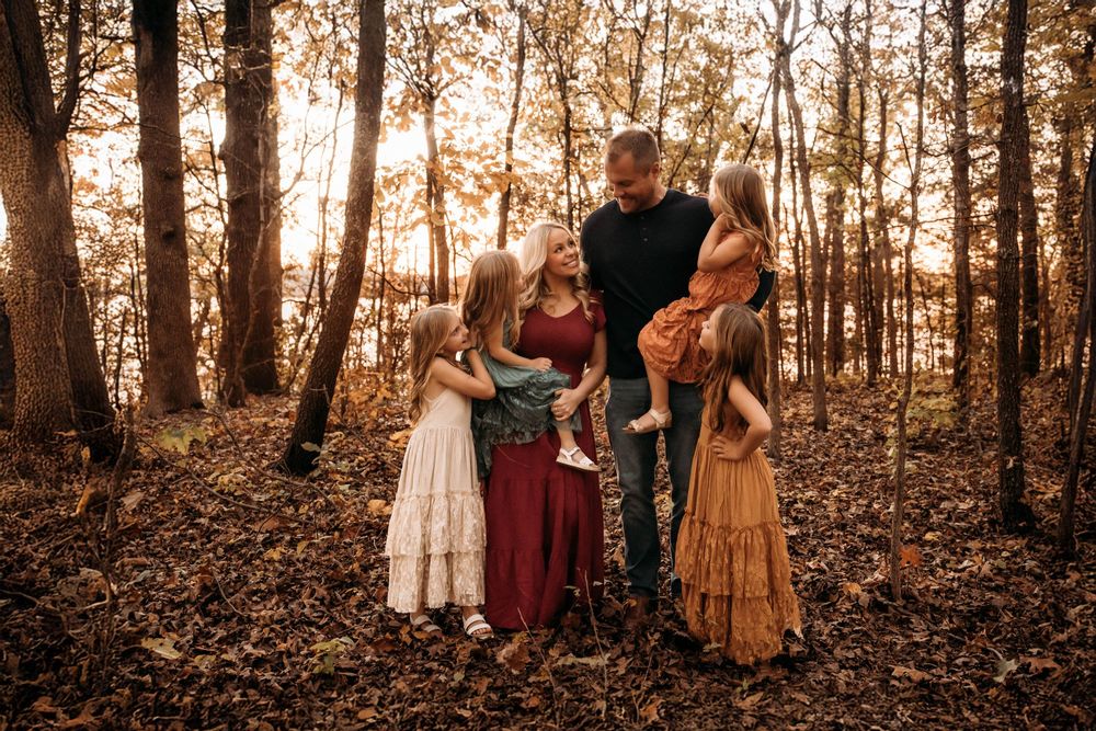 Large family portrait in a sun-drenched Branson forest during an autumn photo session in Branson, Mo.