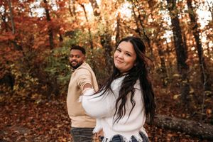 Romantic couple portrait in the vibrant red fall foliage of a Branson, Missouri forest.