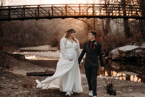 Bride and groom walking by a moody rustic bridge for a Branson wedding photo session at Stockstill River in Branson MO.