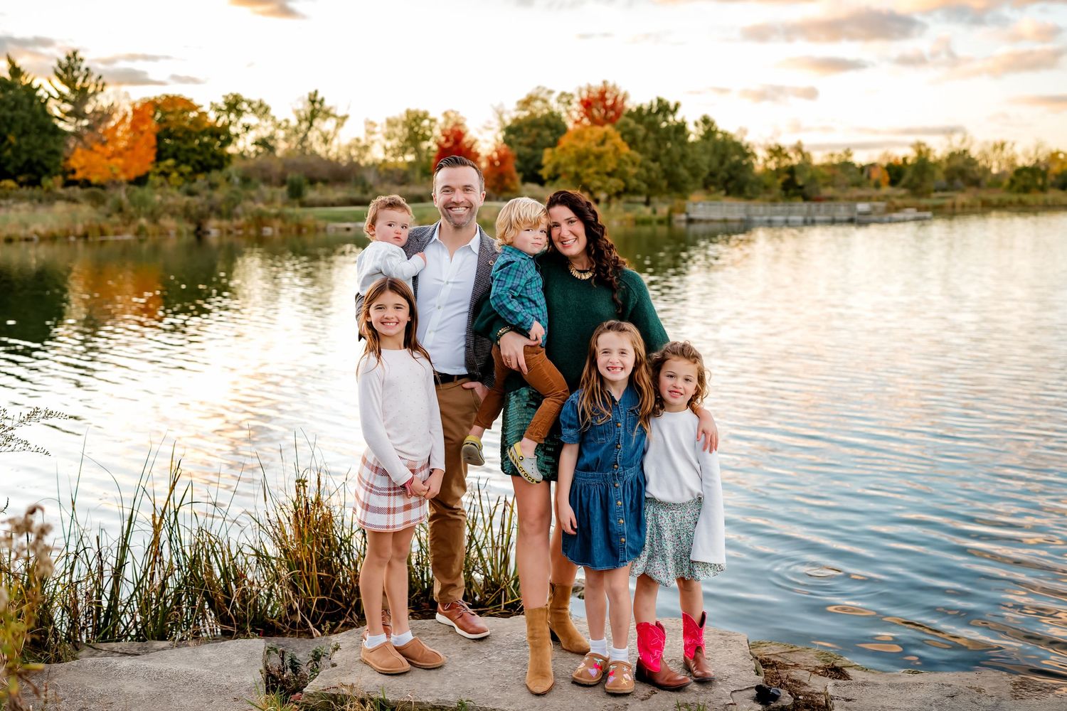 Multi-generational family standing together on garden path surrounded by lush greenery.