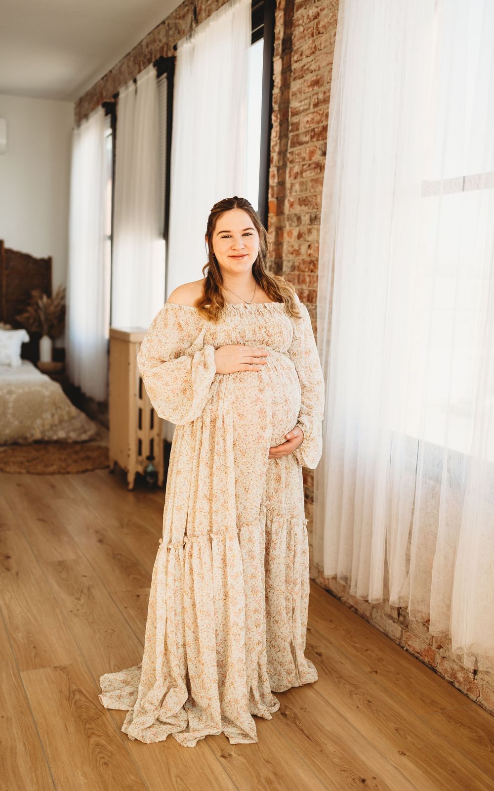 A floral babydoll dress with puff sleeves is shown in multiple views on a hardwood floor with exposed brick walls.