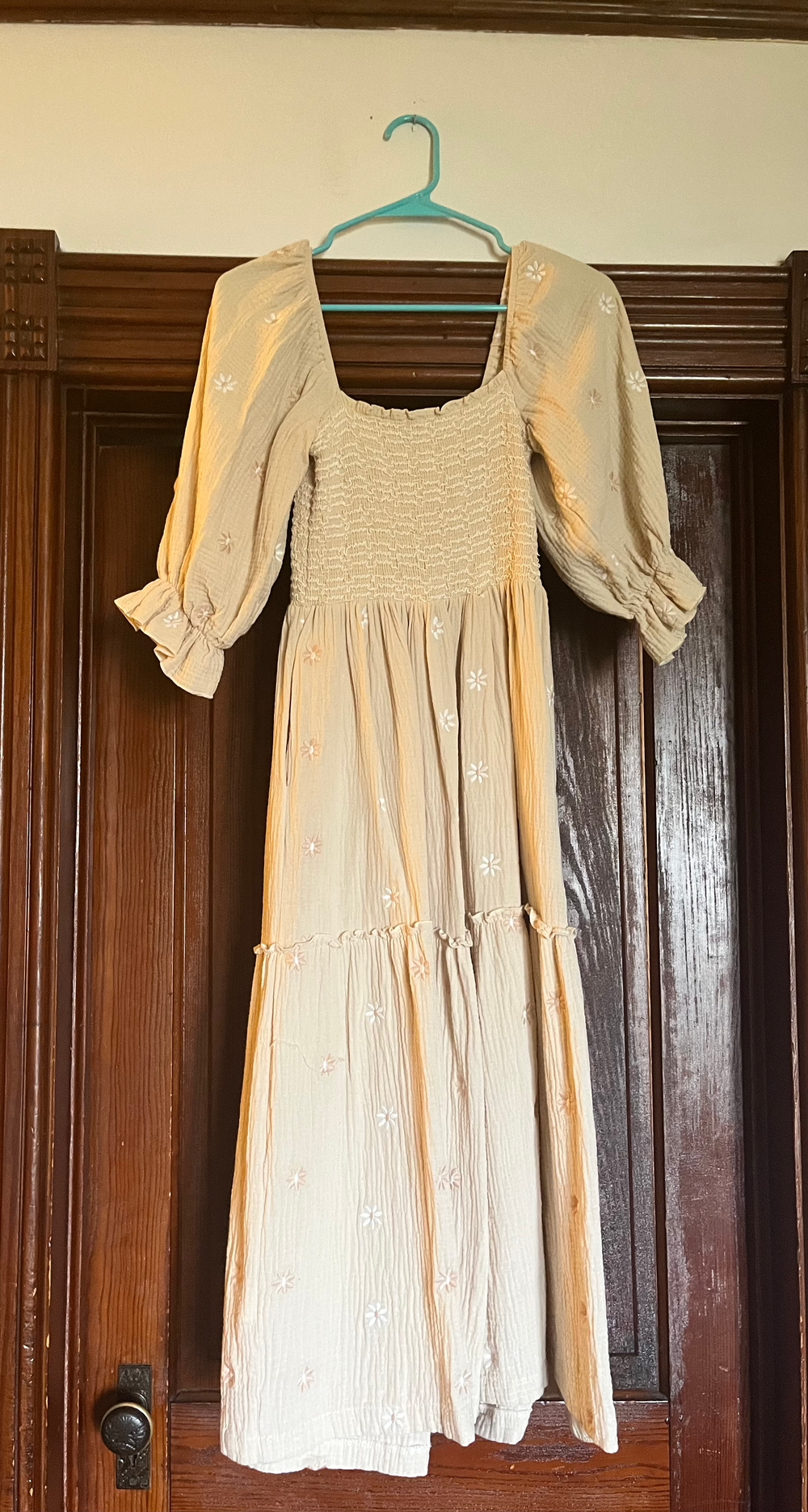 Beige floral embroidered midi dress with puff sleeves, square neckline, smocked bodice, and tiered skirt on a hanger.
