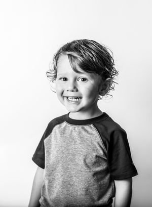 A smiling toddler boy in black and white