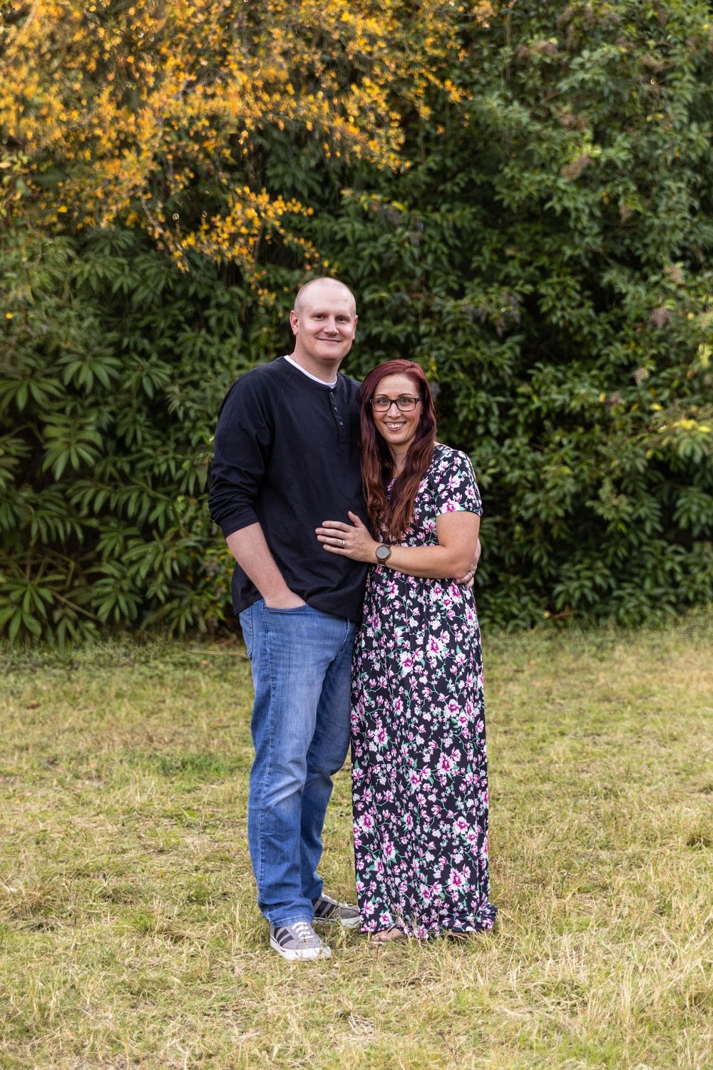 A couple poses in the park.
