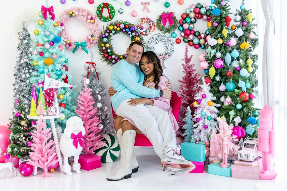 A couple poses in a Christmas studio setting.