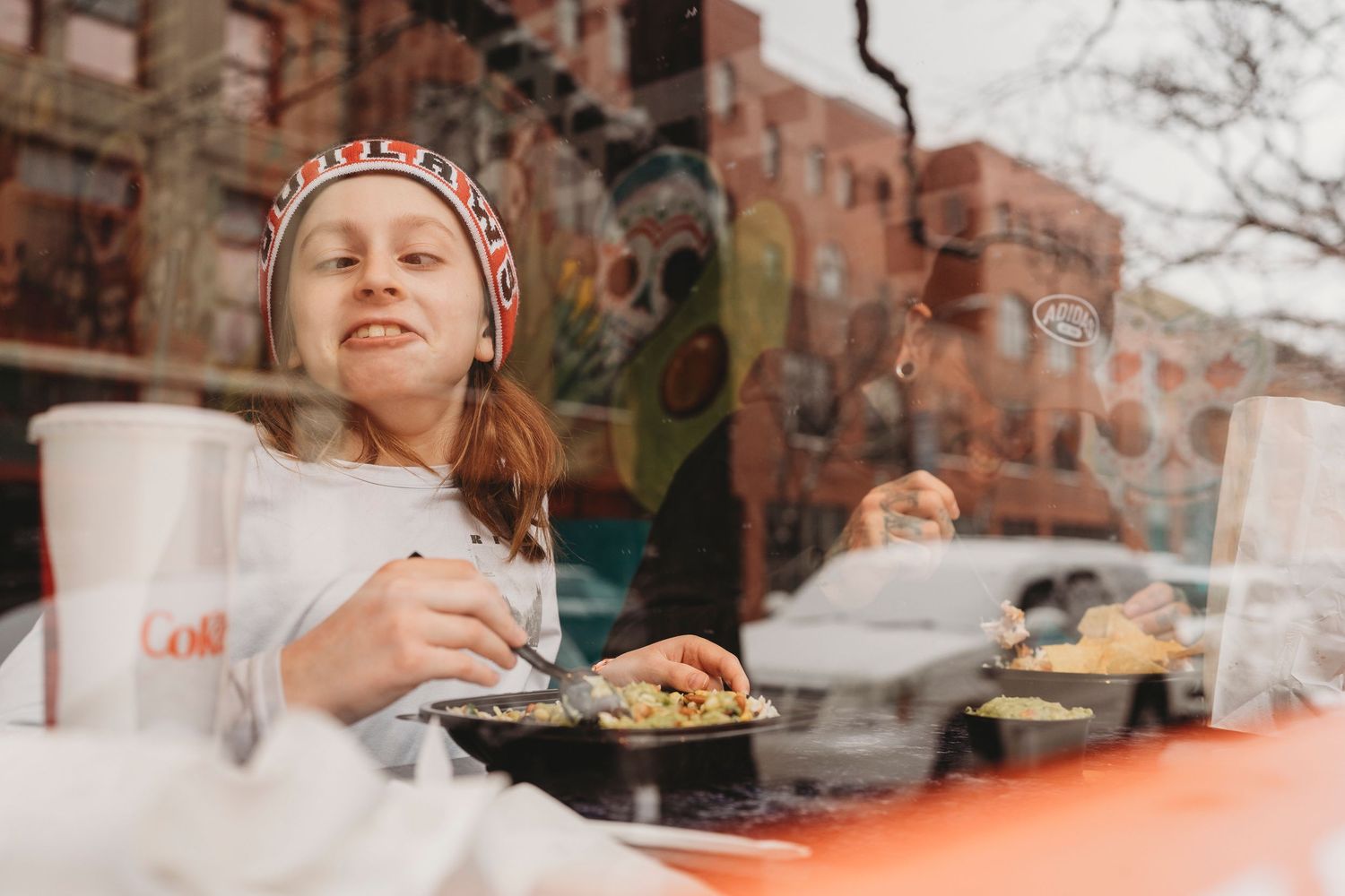 A collage of people enjoying meals and dining experiences at a casual restaurant with brick walls visible in the background.