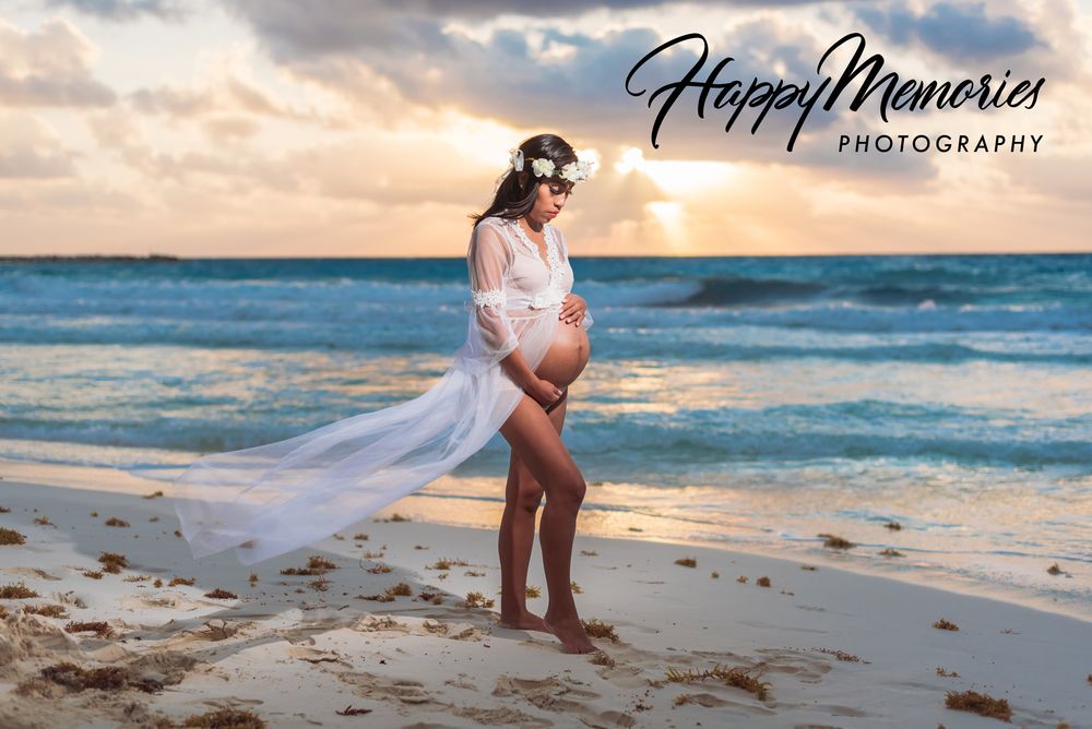 Sunset beach maternity session with flowing veil and golden light.