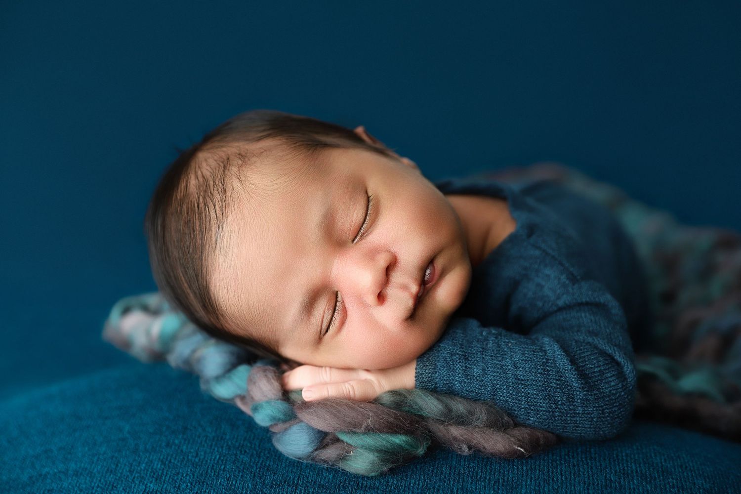 Newborn baby posed on blue backdrop during Central Florida newborn photography session.