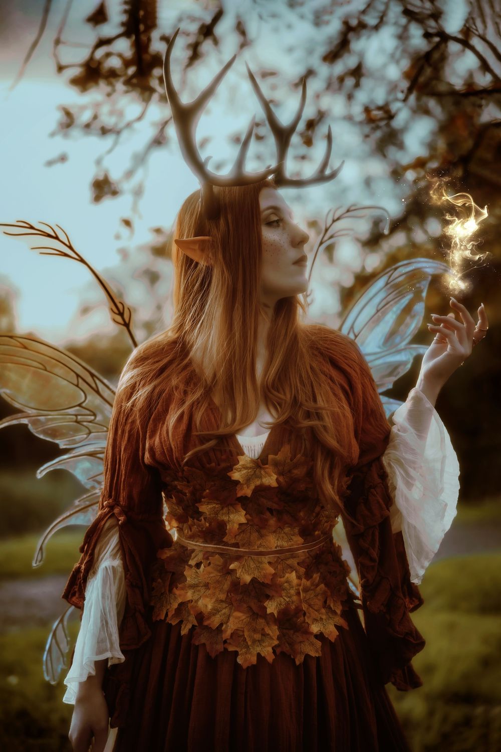 Ethereal autumn scene with flowing white fabric and golden leaves swirling in a mystical woodland setting.