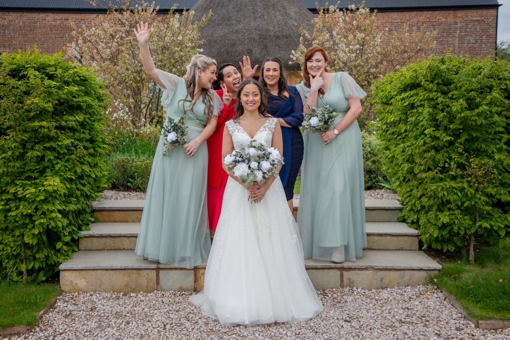 Bride and Bridesmaids posing for a photo on the steps of a venue