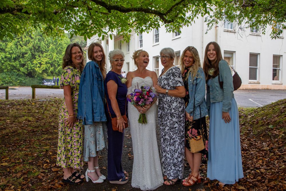 Bride and bridesmaids posing for a photo outside a venue