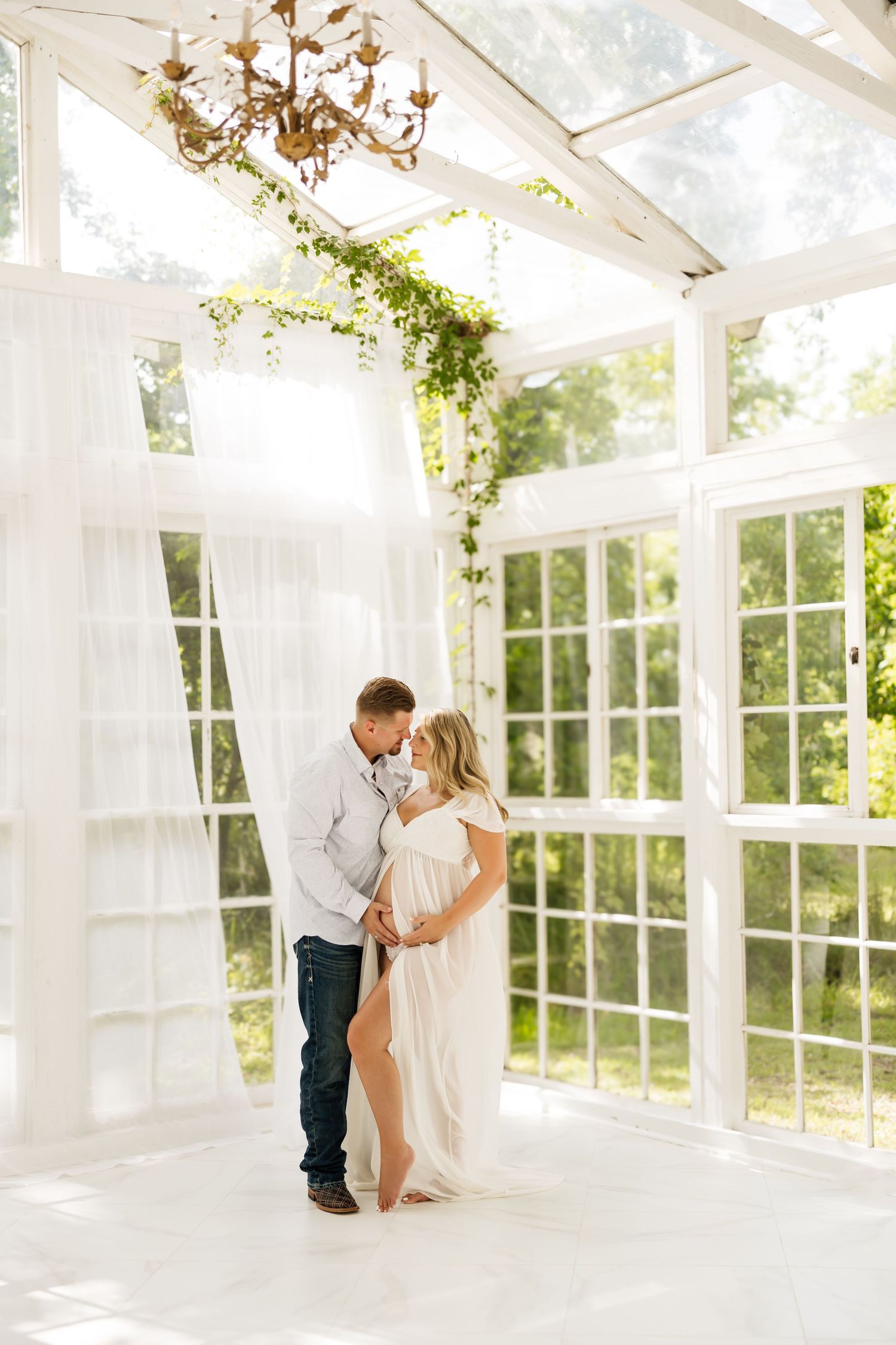 Maternity photography session in Magnolia TX featuring elegant motherhood portraits in a glass house