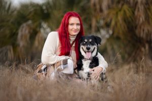 Heartwarming portrait of a pet owner with her beloved pup in a beautiful outdoor setting, capturing their special bond in natural light.