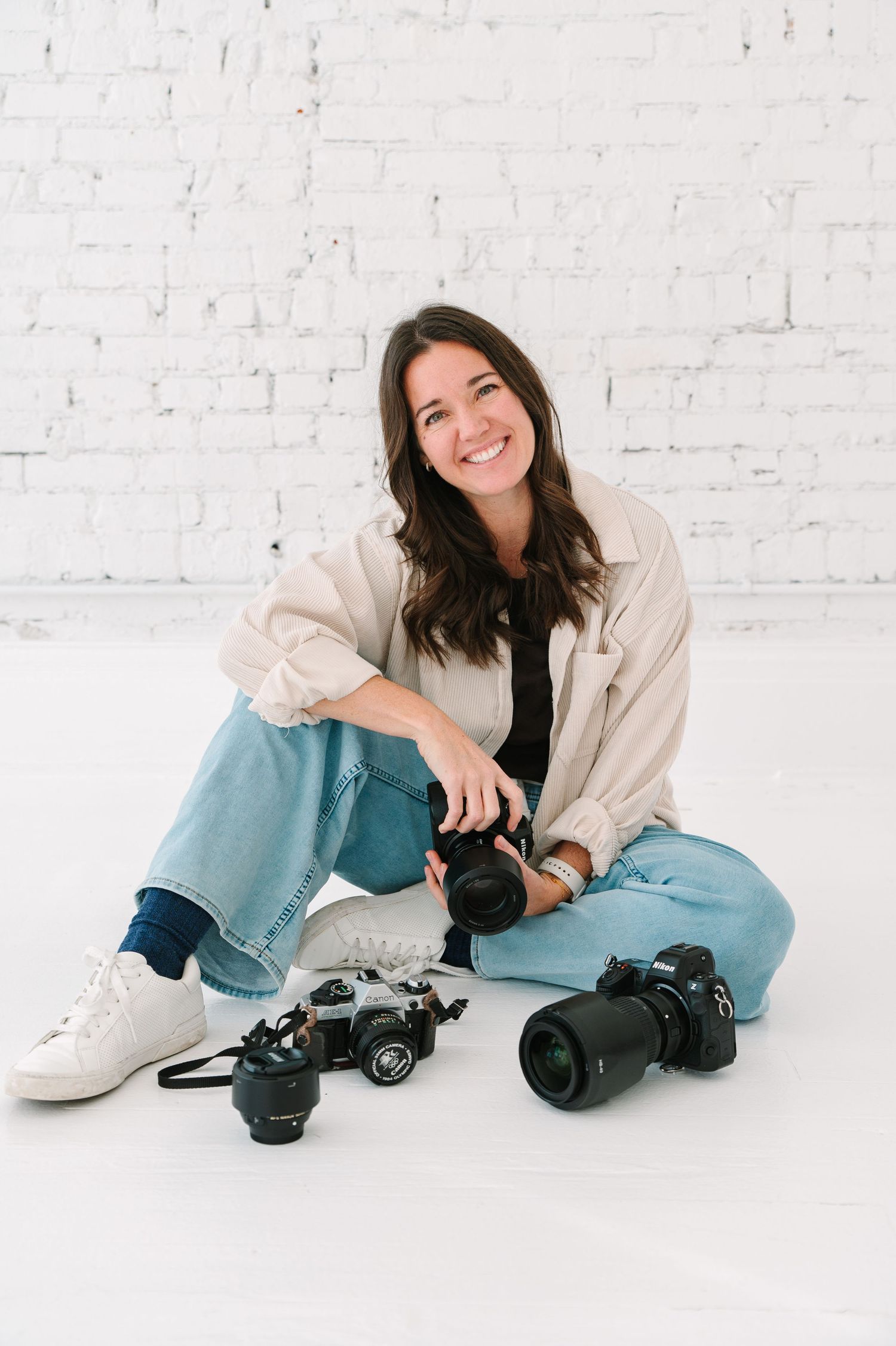 Portrait of person in black sweater and teal pants against white background.