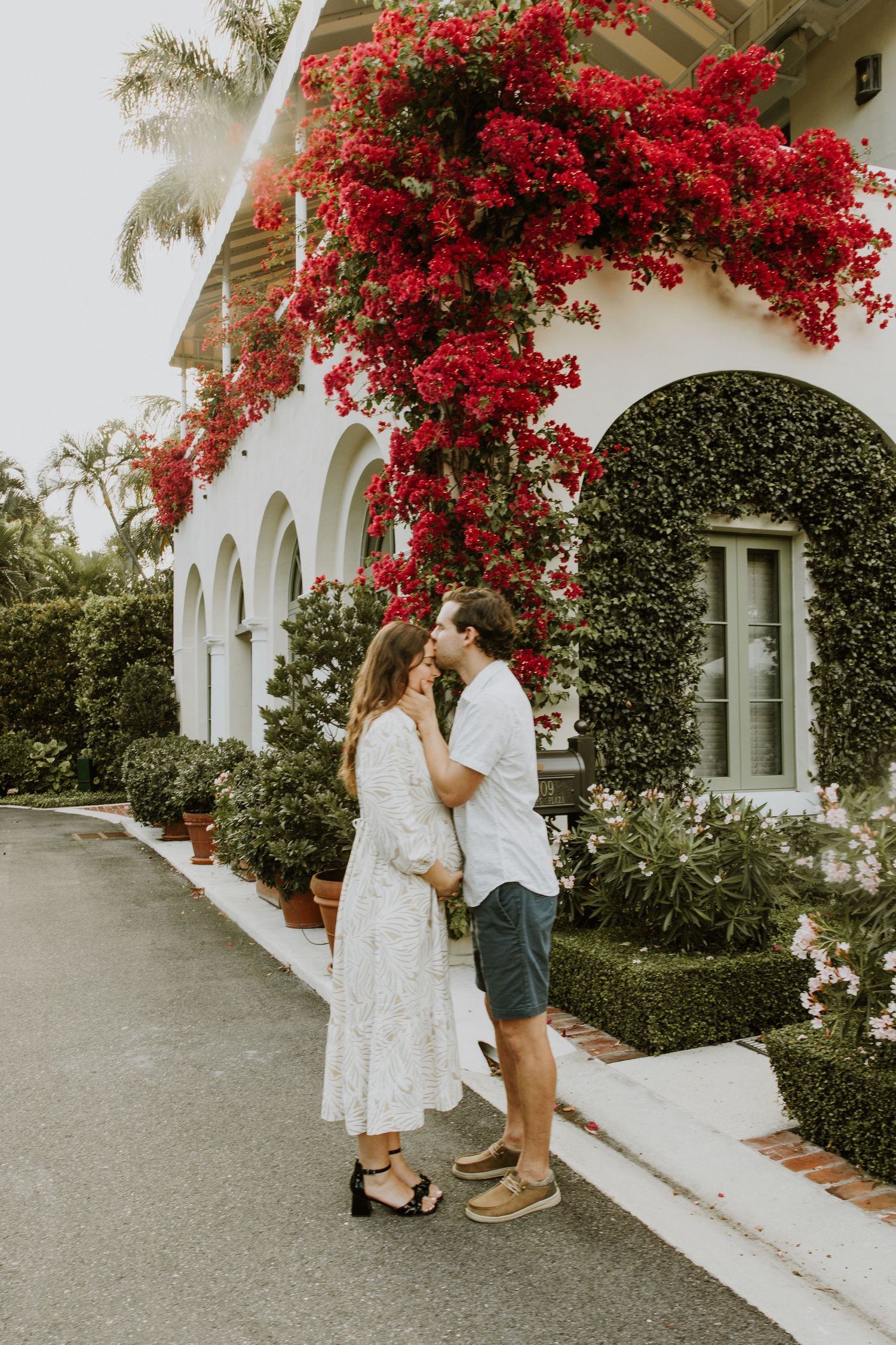 Golden Hour Maternity Session in Palm Beach, Florida captured by Lindsay McDow Photography featuring flowers, foliage, arches, and stairs