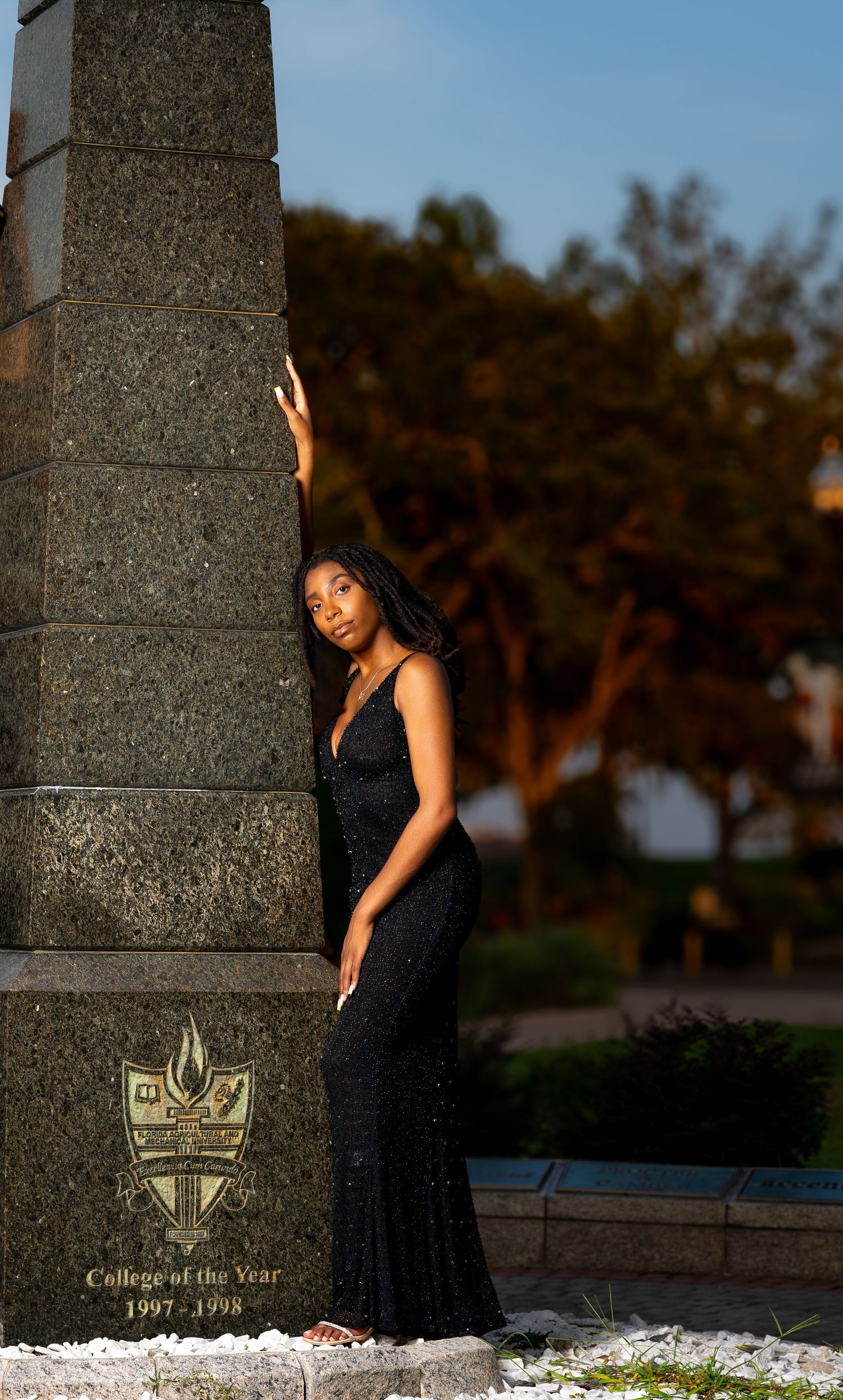 Evening formal portrait against stone monument with engraved plaque.