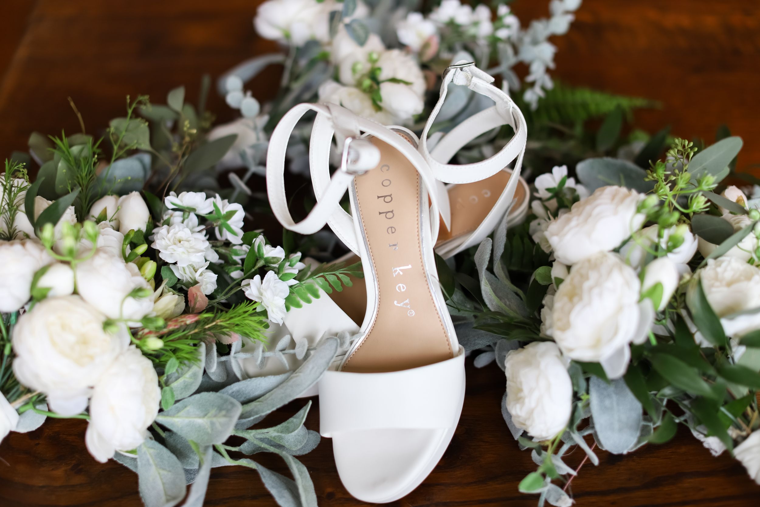 brides shoes and bridesmaid flowers flat lay