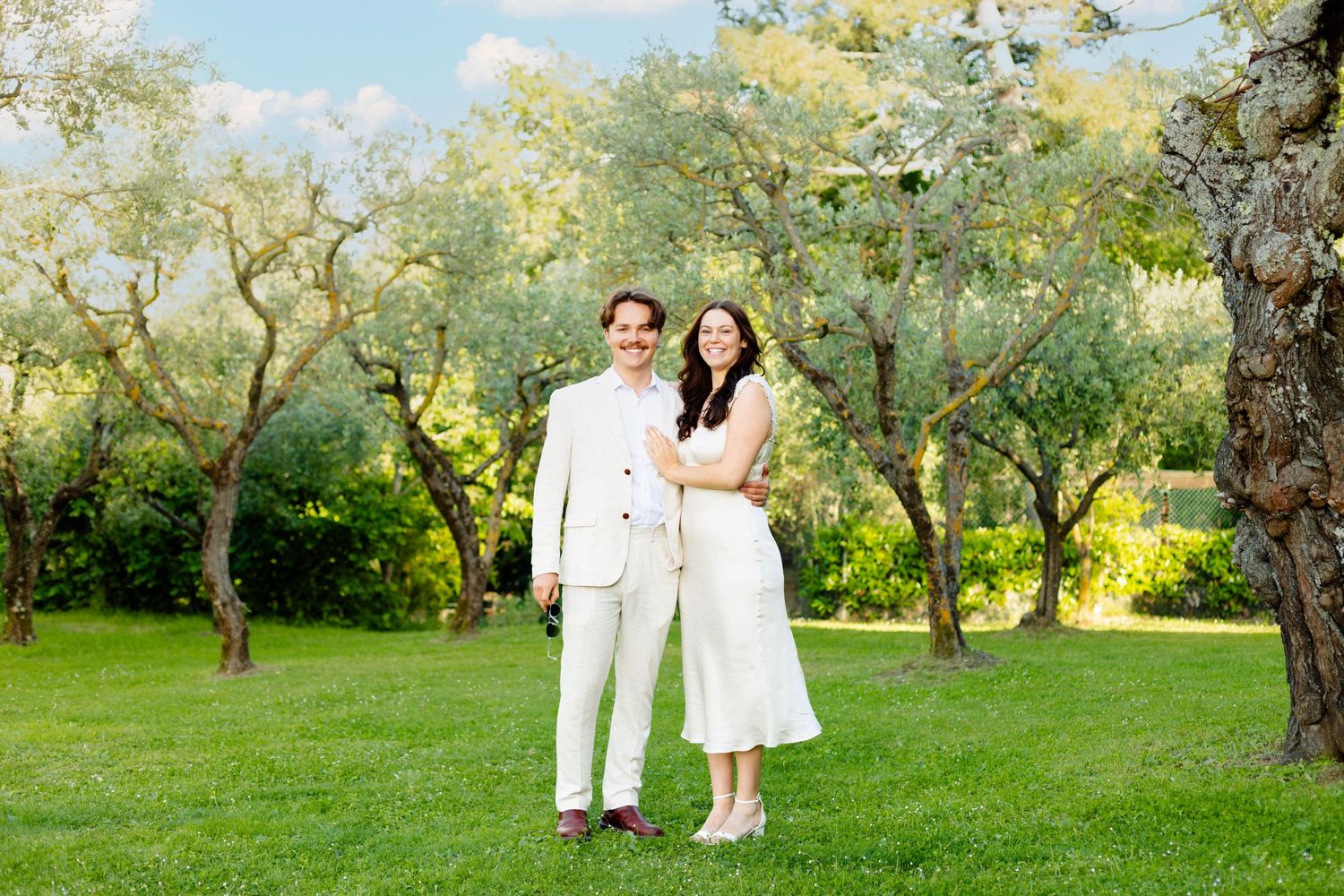 Beautiful outdoor garden wedding scene with olive trees and natural lighting.