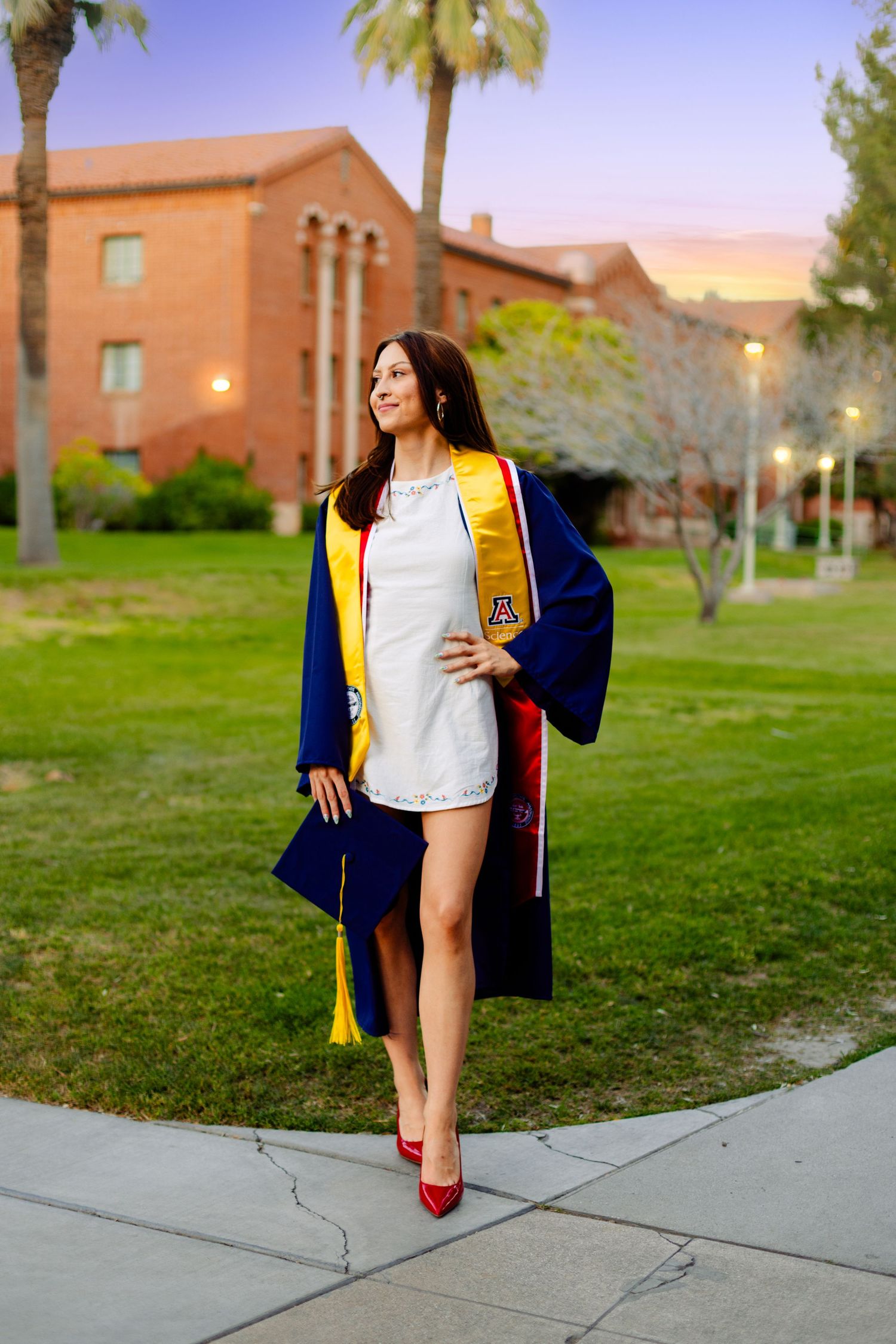 Graduation photos on campus with blue and gold academic regalia.