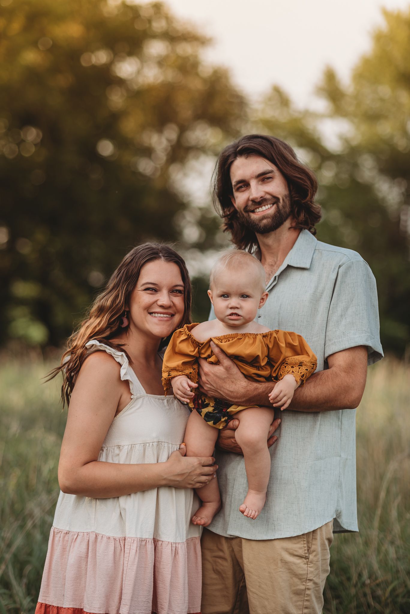 family standing in tall grass, smiling