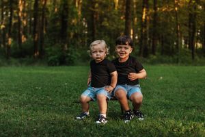 little boys in front of a tree line