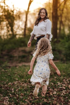 little blonde girl running to her mom, standing in sunset