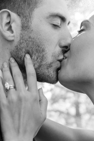 A black and white photo series showing an intimate kiss with hands gently touching faces.