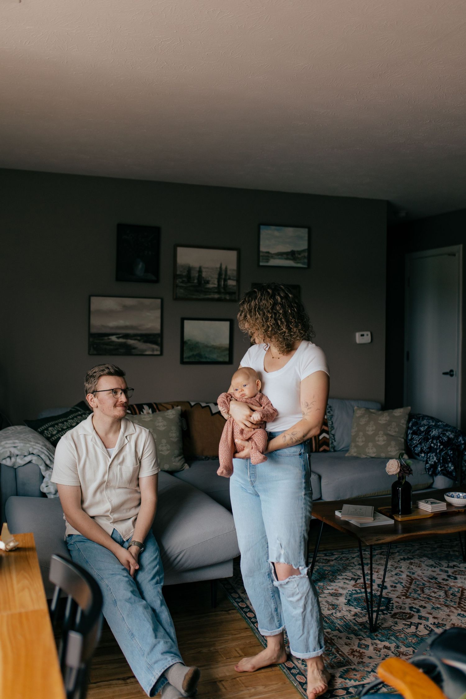 Two people share intimate moments in a living room, showing connection through casual interactions and body language.