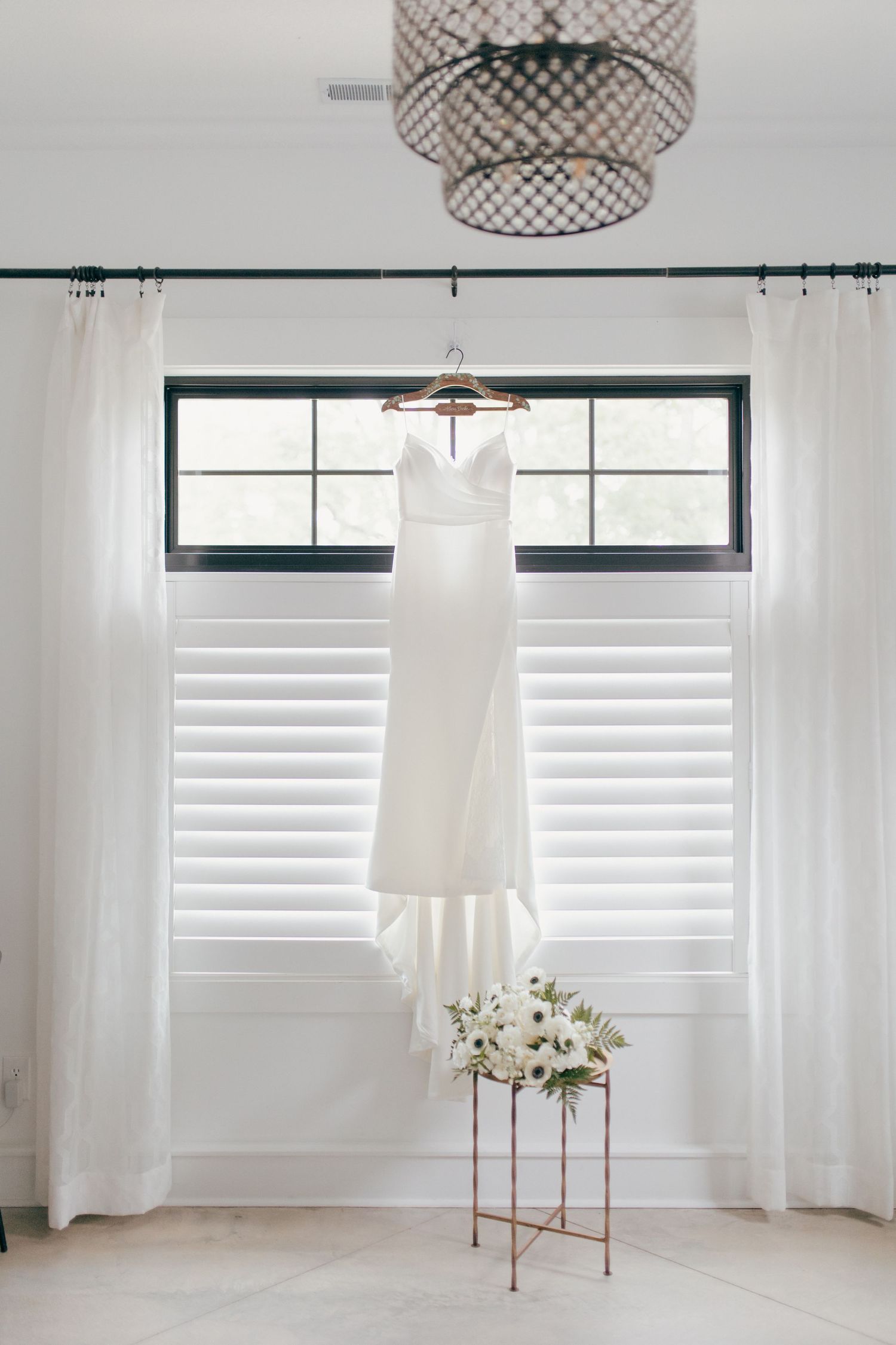 Modern white pendant lamps with woven mesh shades hang elegantly in a bright minimalist room with white curtains and windows.