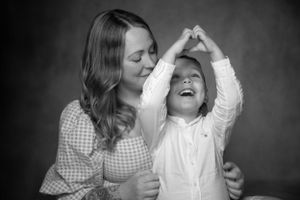 Black and white portrait of a parent and child sharing a joyful moment together while dancing or twirling.