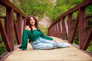 A rustic wooden bridge surrounded by lush greenery in a peaceful outdoor setting.