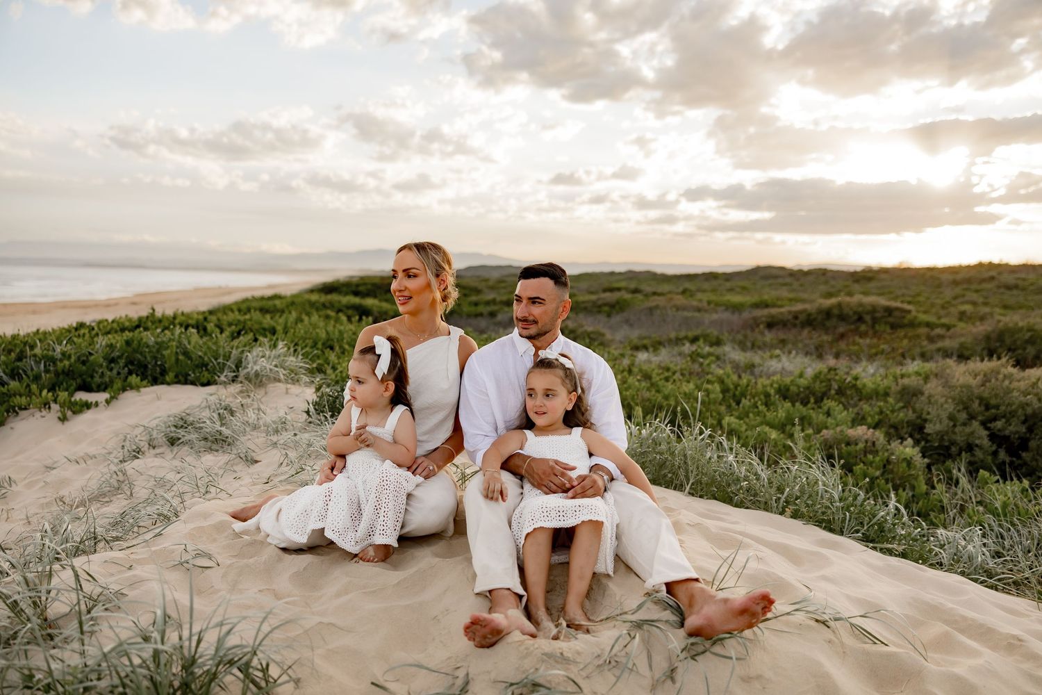 A family stands together on a desert trail with dramatic rock formations in background.