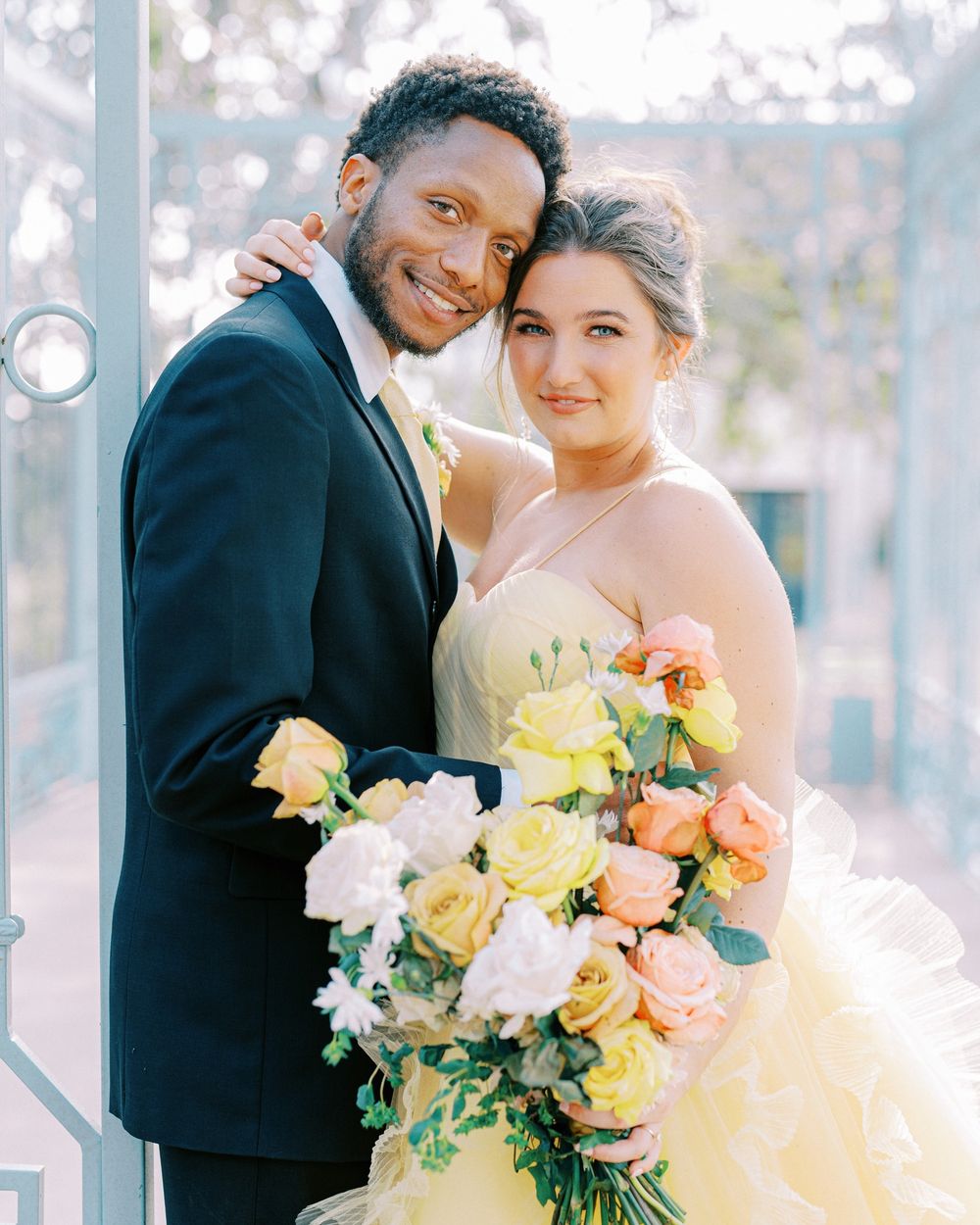 Romantic wedding scene with floral bouquet featuring peach and yellow roses in natural lighting.