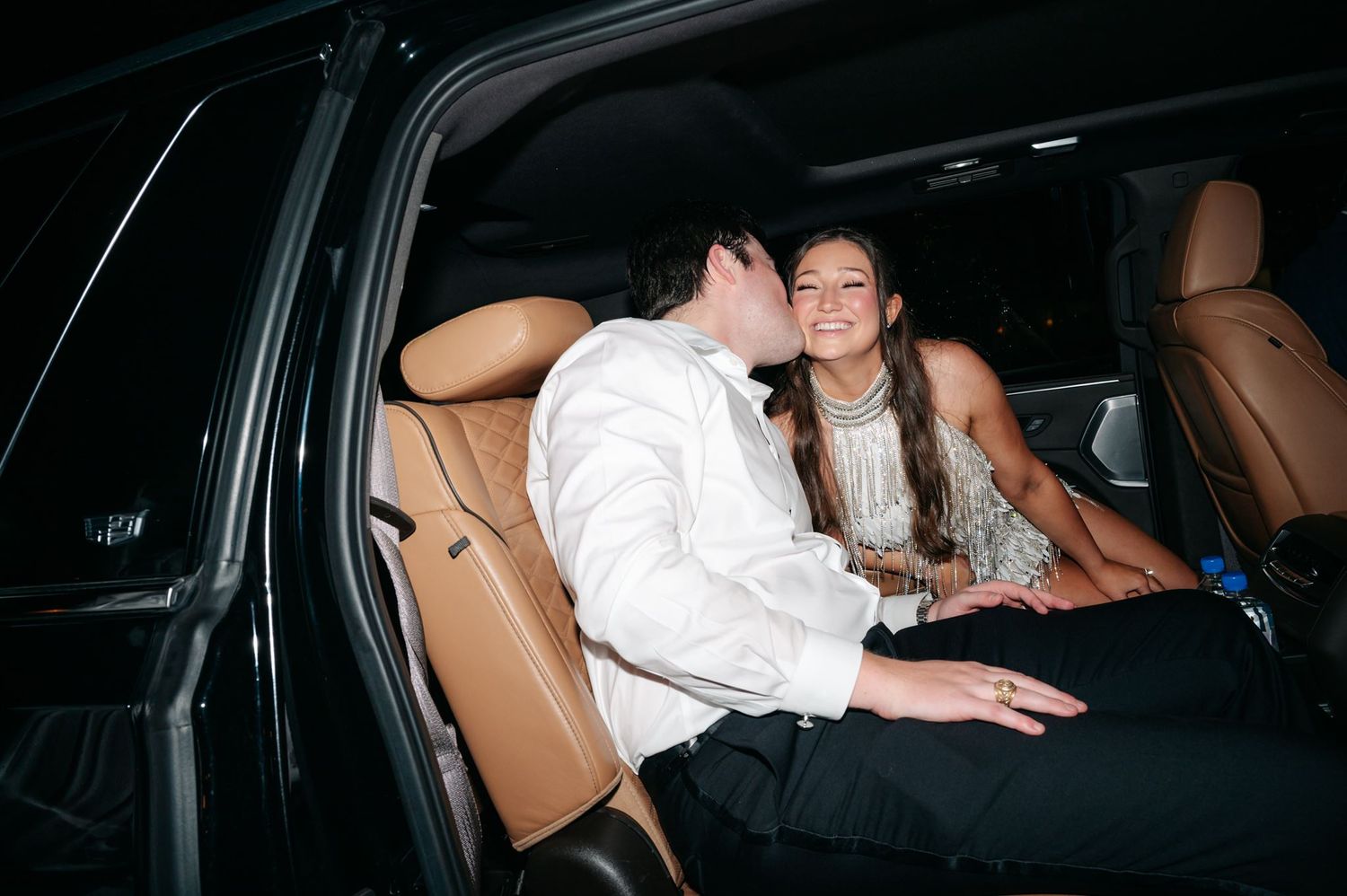 Bride and groom sharing a kiss in their post wedding getaway car.
