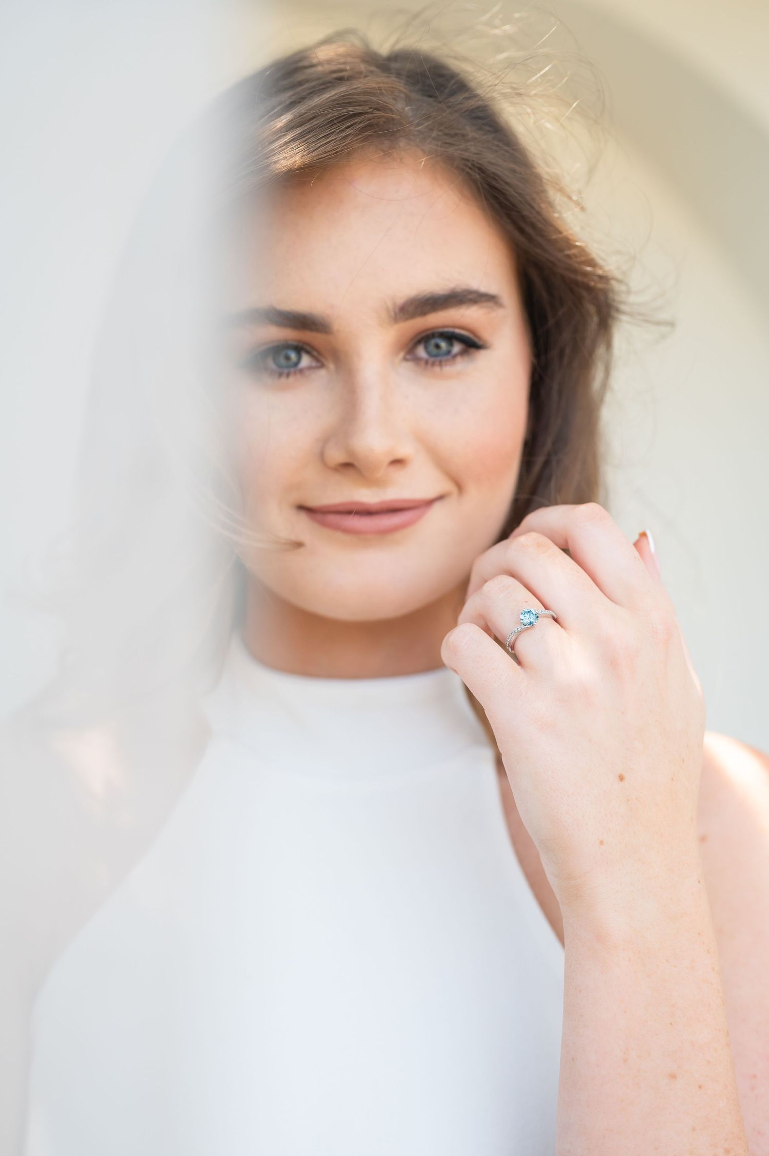 A soft focus portrait photo showing a person against a light background with dreamy ethereal lighting.