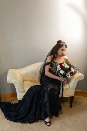 Milestones Studios LLC, Milestones Portraits wedding photography, Castle Gardens Kuna, Idaho bride sitting on loveseat wearing black gown